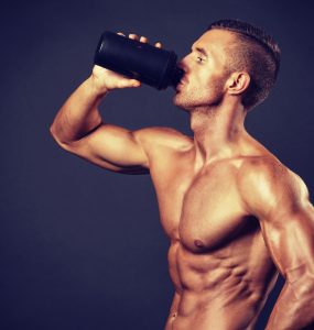 Voedingssupplementen: een sporter drinkt een eiwitshake